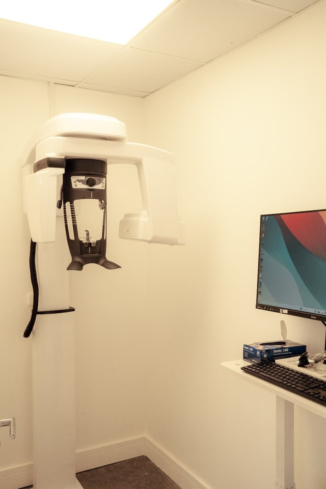 A BDSI Clinic treatment room with worktop, sink and branded wall panel
